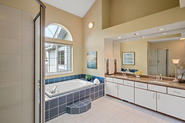 full bath with a stall shower, double vanity, a garden tub, tile patterned flooring, and high vaulted ceiling