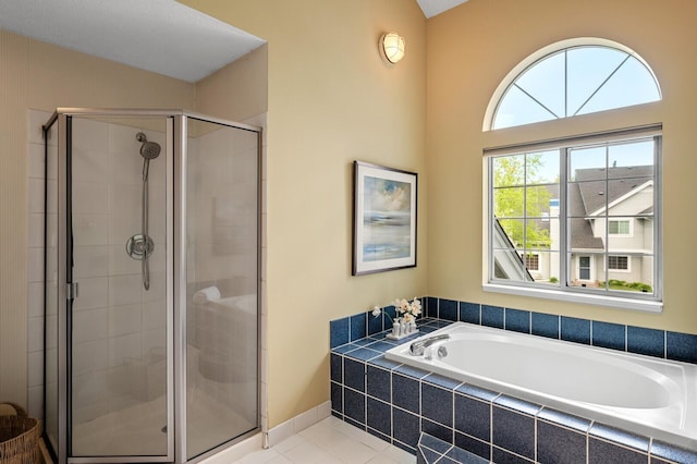 bathroom with a shower stall, a garden tub, and tile patterned floors