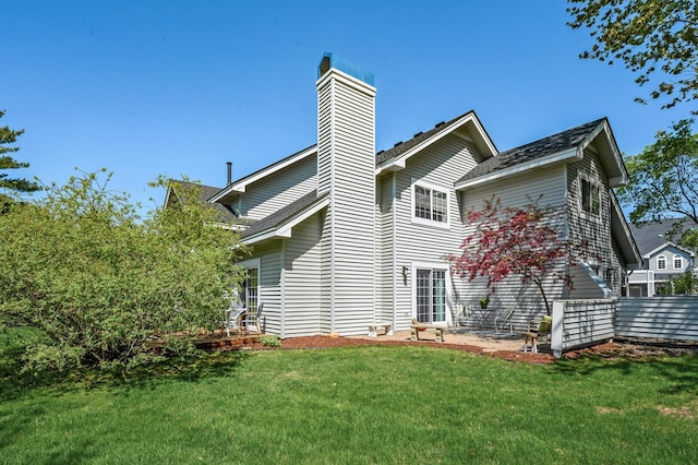rear view of property featuring a lawn and a chimney