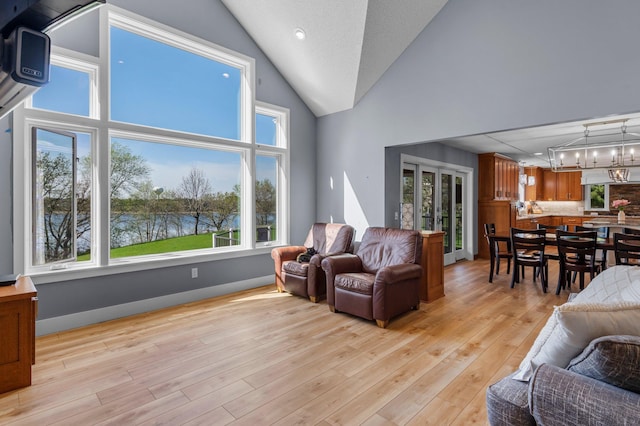 19776 214th Ave NW, Big Lake Twp, MN 55309 - living area featuring light wood-type flooring, a chandelier, and high vaulted ceiling