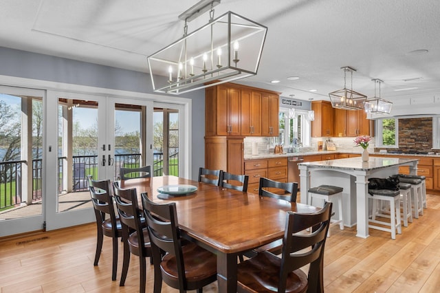 19776 214th Ave NW, Big Lake Twp, MN 55309 - dining space with light wood finished floors, french doors, plenty of natural light, a chandelier, and recessed lighting