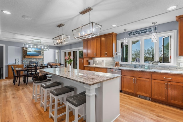 19776 214th Ave NW, Big Lake Twp, MN 55309 - kitchen featuring brown cabinetry, dishwasher, tasteful backsplash, light wood-style flooring, and recessed lighting