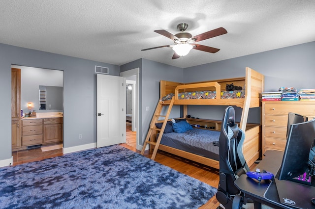 19776 214th Ave NW, Big Lake Twp, MN 55309 - bedroom with an office area, a textured ceiling, wood finished floors, ensuite bath, and a ceiling fan