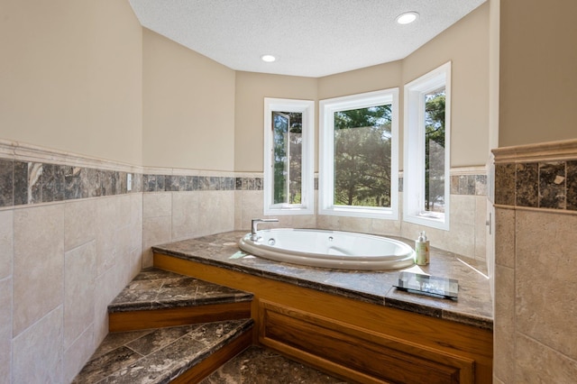 19776 214th Ave NW, Big Lake Twp, MN 55309 - full bath featuring a bath, a textured ceiling, tile walls, and wainscoting