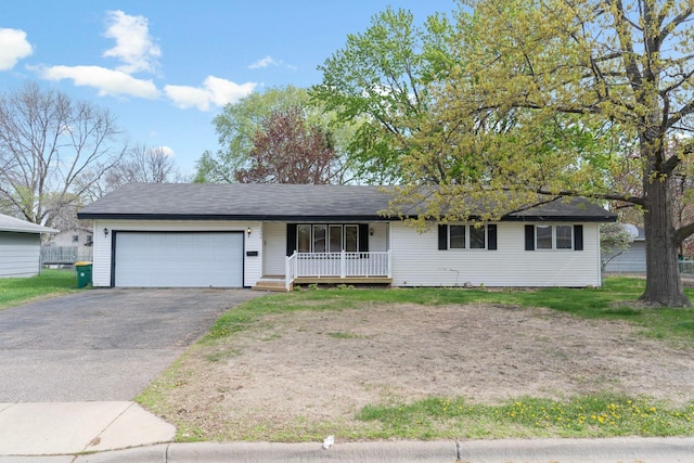 single story home featuring driveway, covered porch, and a garage