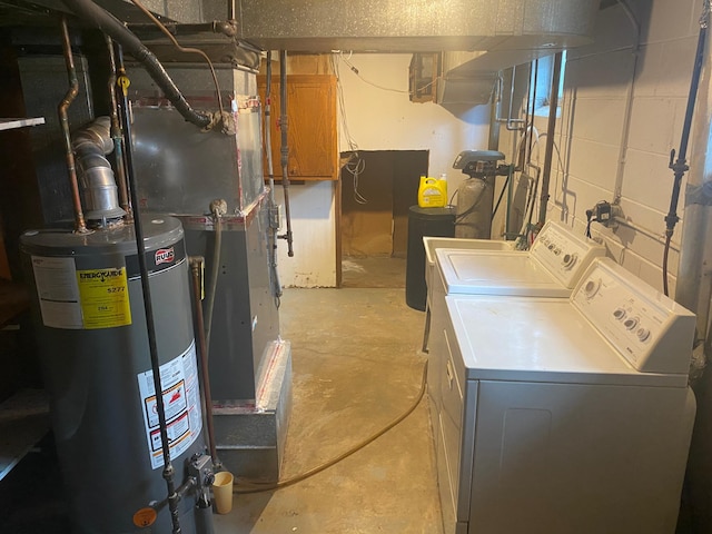 laundry room with washer and dryer, water heater, and concrete block wall