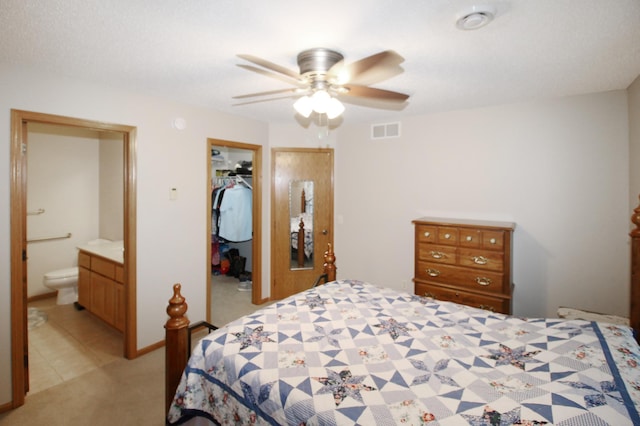 4129 6th St S, Saint Cloud, MN 56301 - bedroom with light carpet, a walk in closet, a closet, ceiling fan, and ensuite bath