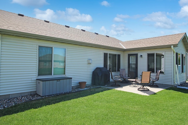 4129 6th St S, Saint Cloud, MN 56301 - back of property featuring a lawn, a patio, and roof with shingles