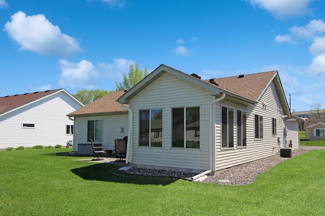 4129 6th St S, Saint Cloud, MN 56301 - rear view of house with a yard, a shingled roof, a patio, and cooling unit