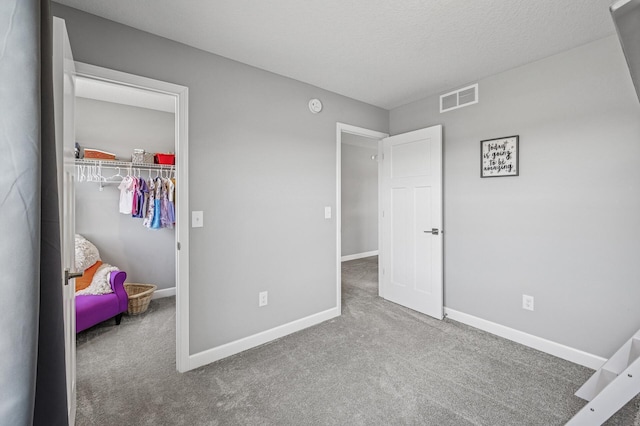 104 Hummingbird Way, Delano, MN 55328 - carpeted bedroom featuring baseboards, a closet, a walk in closet, and a textured ceiling