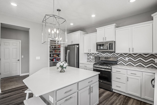 104 Hummingbird Way, Delano, MN 55328 - kitchen with appliances with stainless steel finishes, light countertops, white cabinets, a chandelier, and dark wood-type flooring