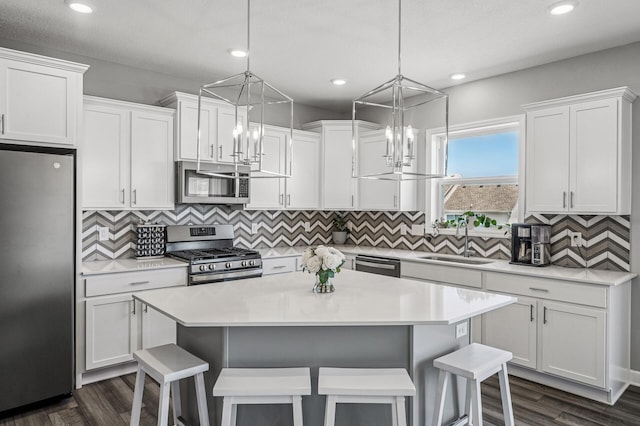 104 Hummingbird Way, Delano, MN 55328 - kitchen with stainless steel appliances, white cabinetry, a breakfast bar, light countertops, and a center island