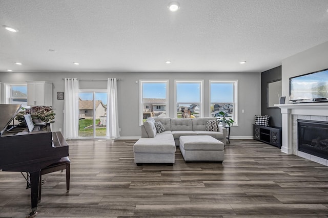 104 Hummingbird Way, Delano, MN 55328 - living area featuring dark wood-type flooring, recessed lighting, a textured ceiling, and a tiled fireplace