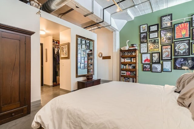 730 Stinson Blvd Unit 205, Minneapolis, MN 55413 - bedroom with a walk in closet, finished concrete flooring, and baseboards