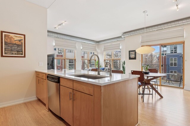 2845 Colfax Ave S Unit W202, Minneapolis, MN 55408 - kitchen featuring rail lighting, stainless steel dishwasher, a sink, light wood-style floors, and light countertops