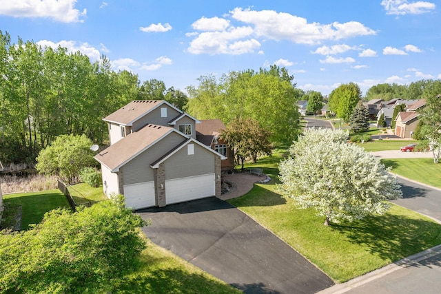 view of front of home featuring asphalt driveway and a front lawn