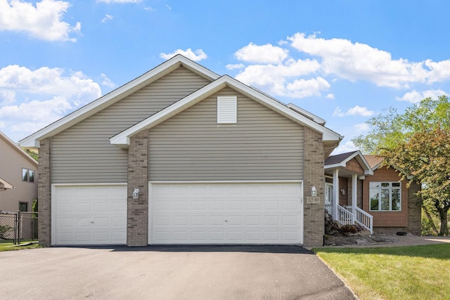 view of front of house with driveway, brick siding, and an attached garage