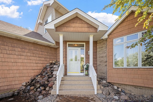 doorway to property with a shingled roof