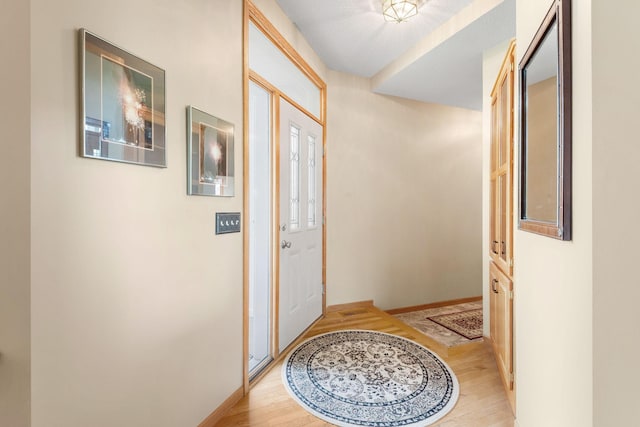doorway to outside with wood finished floors and baseboards