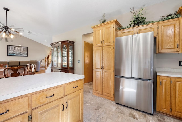 kitchen featuring freestanding refrigerator, light countertops, vaulted ceiling, a chandelier, and open floor plan
