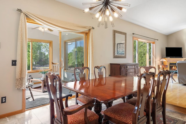 dining space with a chandelier, baseboards, and vaulted ceiling