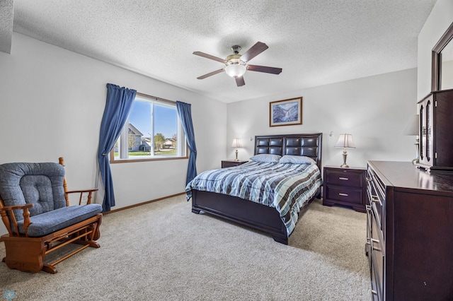 bedroom with light colored carpet, a textured ceiling, baseboards, and a ceiling fan