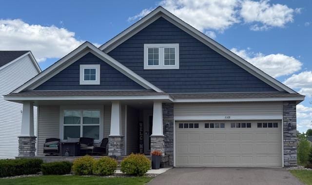 6168 Quenroe Ave NE, Otsego, MN 55330 - craftsman-style home with a porch, stone siding, driveway, and a garage