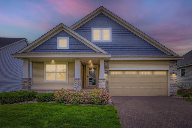 6168 Quenroe Ave NE, Otsego, MN 55330 - craftsman-style house featuring stone siding, asphalt driveway, a porch, a front yard, and an attached garage