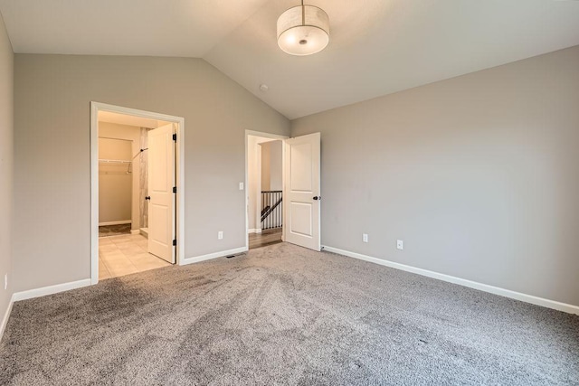 6168 Quenroe Ave NE, Otsego, MN 55330 - unfurnished bedroom with light colored carpet, lofted ceiling, and a spacious closet