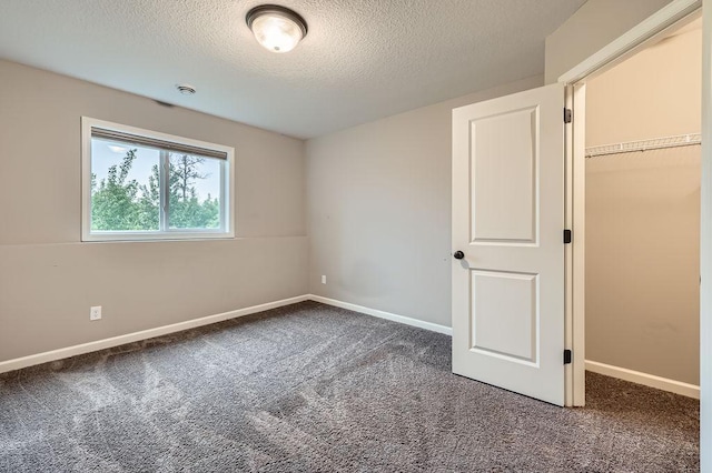 6168 Quenroe Ave NE, Otsego, MN 55330 - unfurnished bedroom with carpet floors, a textured ceiling, and a walk in closet