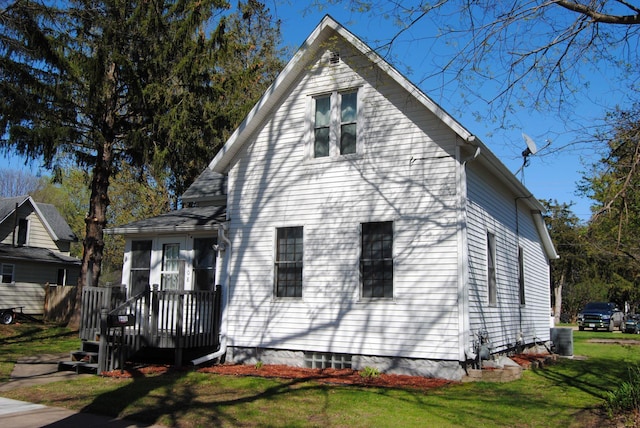 view of front facade featuring a front lawn and central AC