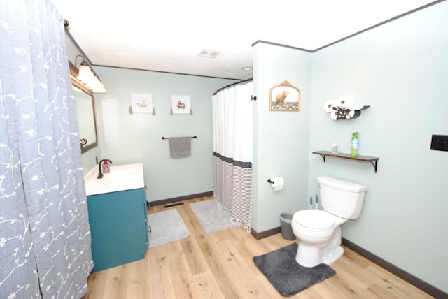 bathroom featuring wood finished floors, vanity, toilet, baseboards, and a shower with shower curtain