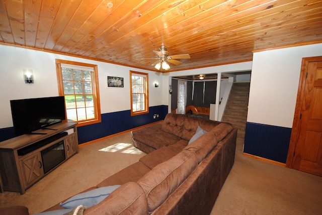 living room with wood ceiling, carpet floors, wainscoting, stairs, and ceiling fan