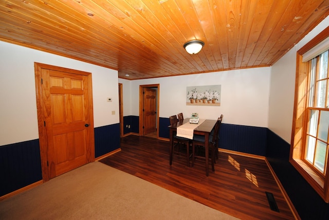 dining area featuring wood ceiling, a wainscoted wall, healthy amount of natural light, wood walls, and wood finished floors