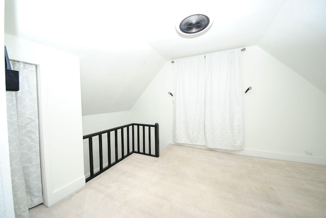 additional living space with vaulted ceiling and carpet