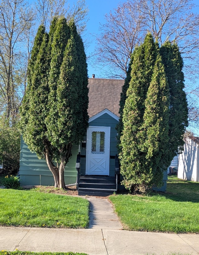 1211 10th Ave SW, Austin, MN 55912 - obstructed view of property featuring a shingled roof and a front yard