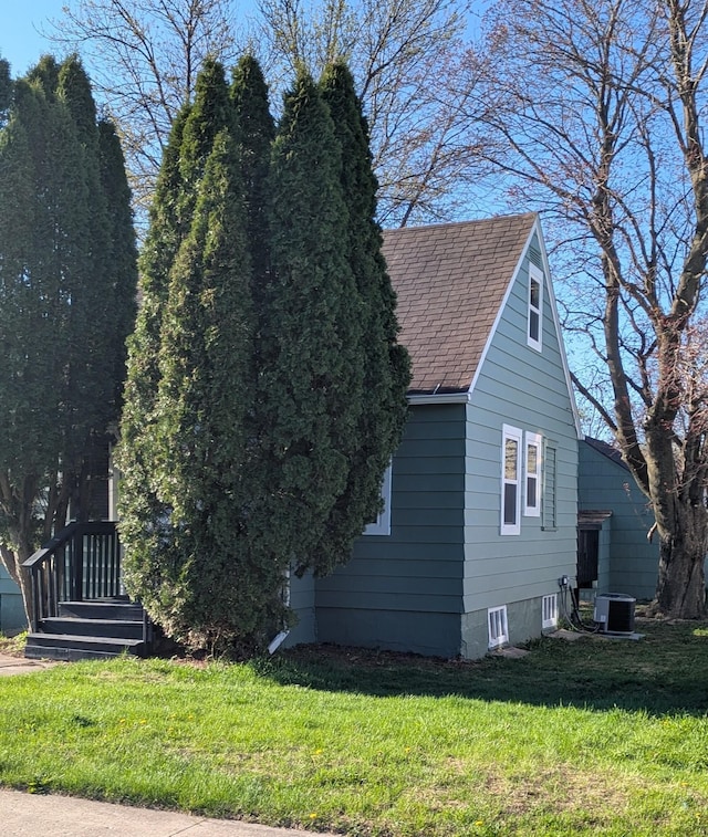 1211 10th Ave SW, Austin, MN 55912 - view of home's exterior featuring a yard, roof with shingles, and central AC