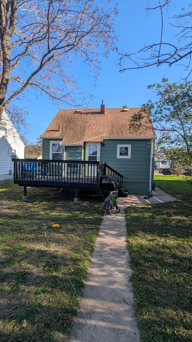 1211 10th Ave SW, Austin, MN 55912 - back of property with a deck, a chimney, and a lawn