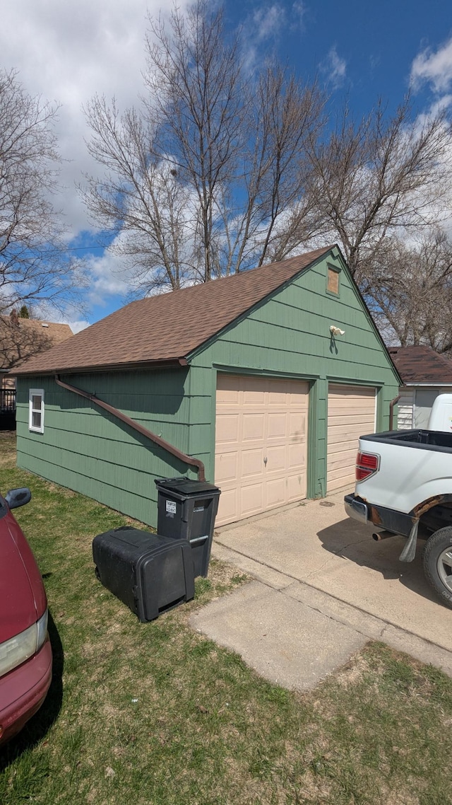 1211 10th Ave SW, Austin, MN 55912 - view of home's exterior with a detached garage, an outbuilding, a shingled roof, and a yard
