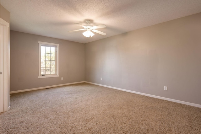 carpeted spare room with a ceiling fan, a textured ceiling, and baseboards