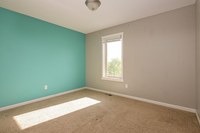 carpeted spare room featuring baseboards
