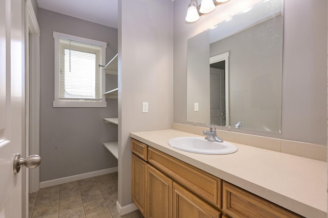 bathroom featuring vanity, tile patterned flooring, and baseboards