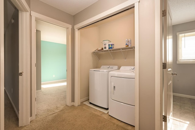 laundry room featuring washer and dryer, baseboards, and light carpet