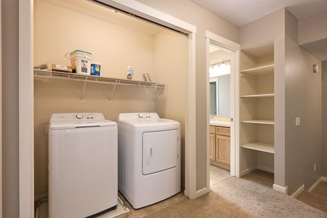 clothes washing area featuring separate washer and dryer, light carpet, and baseboards