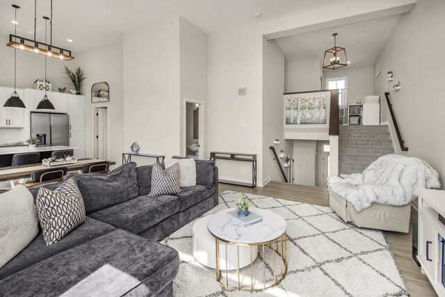 18122 Garland Path, Lakeville, MN 55044 - living area with light wood-style flooring, a towering ceiling, a chandelier, stairway, and recessed lighting