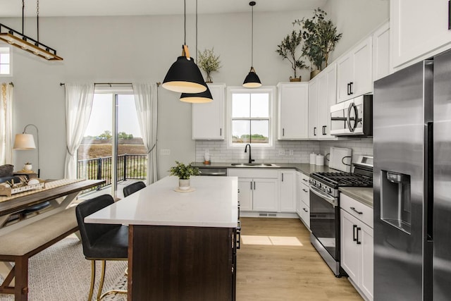 18122 Garland Path, Lakeville, MN 55044 - kitchen featuring stainless steel appliances, a sink, decorative backsplash, a center island, and light wood-type flooring