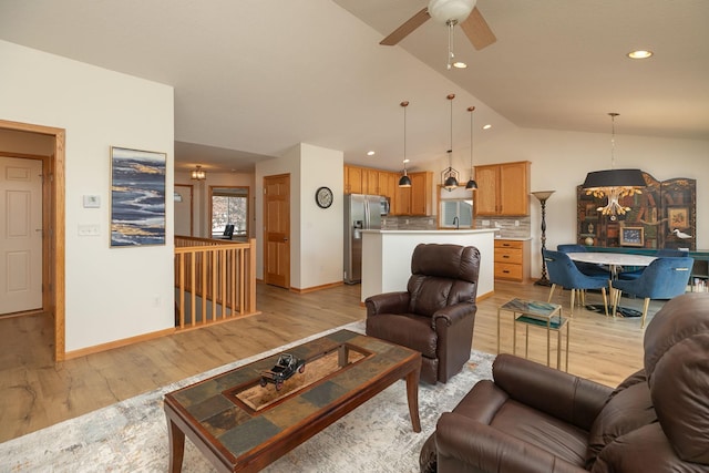 living room featuring lofted ceiling, light wood finished floors, ceiling fan, baseboards, and recessed lighting