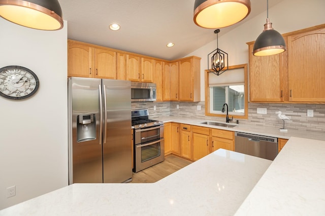 kitchen featuring stainless steel appliances, a sink, light countertops, backsplash, and recessed lighting