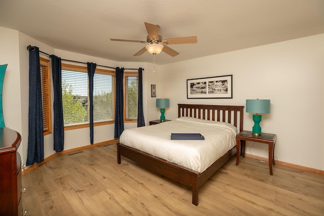 bedroom with baseboards, light wood-style floors, and ceiling fan