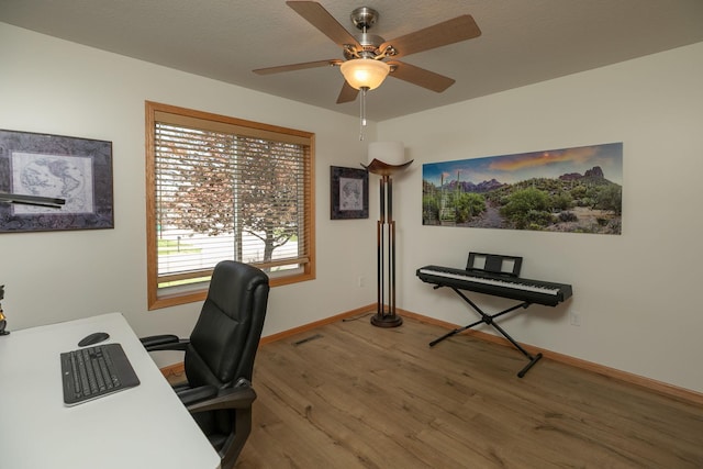 office area with wood finished floors, a ceiling fan, and baseboards